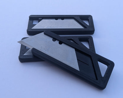 Black multitool with a silver blade on a light blue background